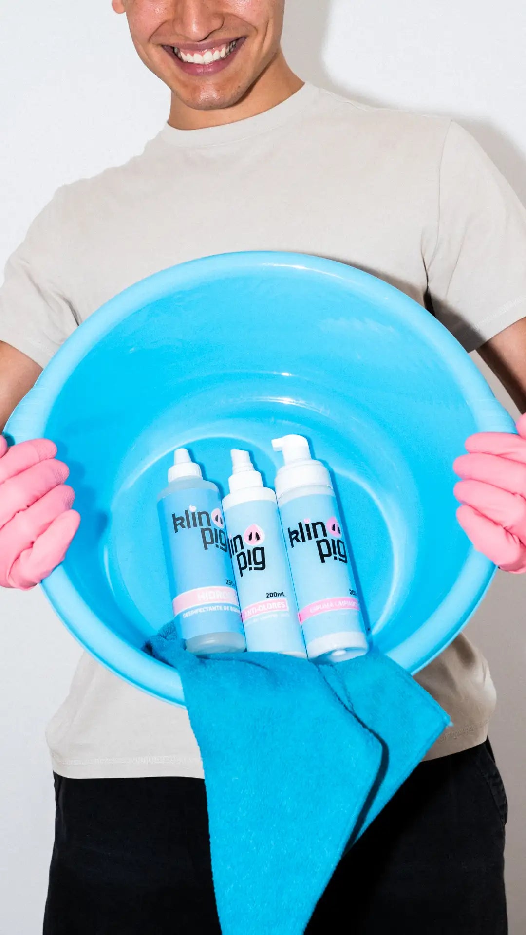 tres envases azules paño microfibra azul guantes rosa persona sonriendo