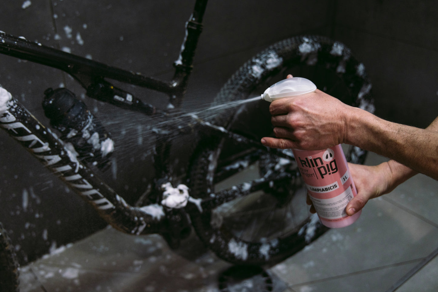 pares oscura bici negra envase con liquido rosa y dosificador de producto