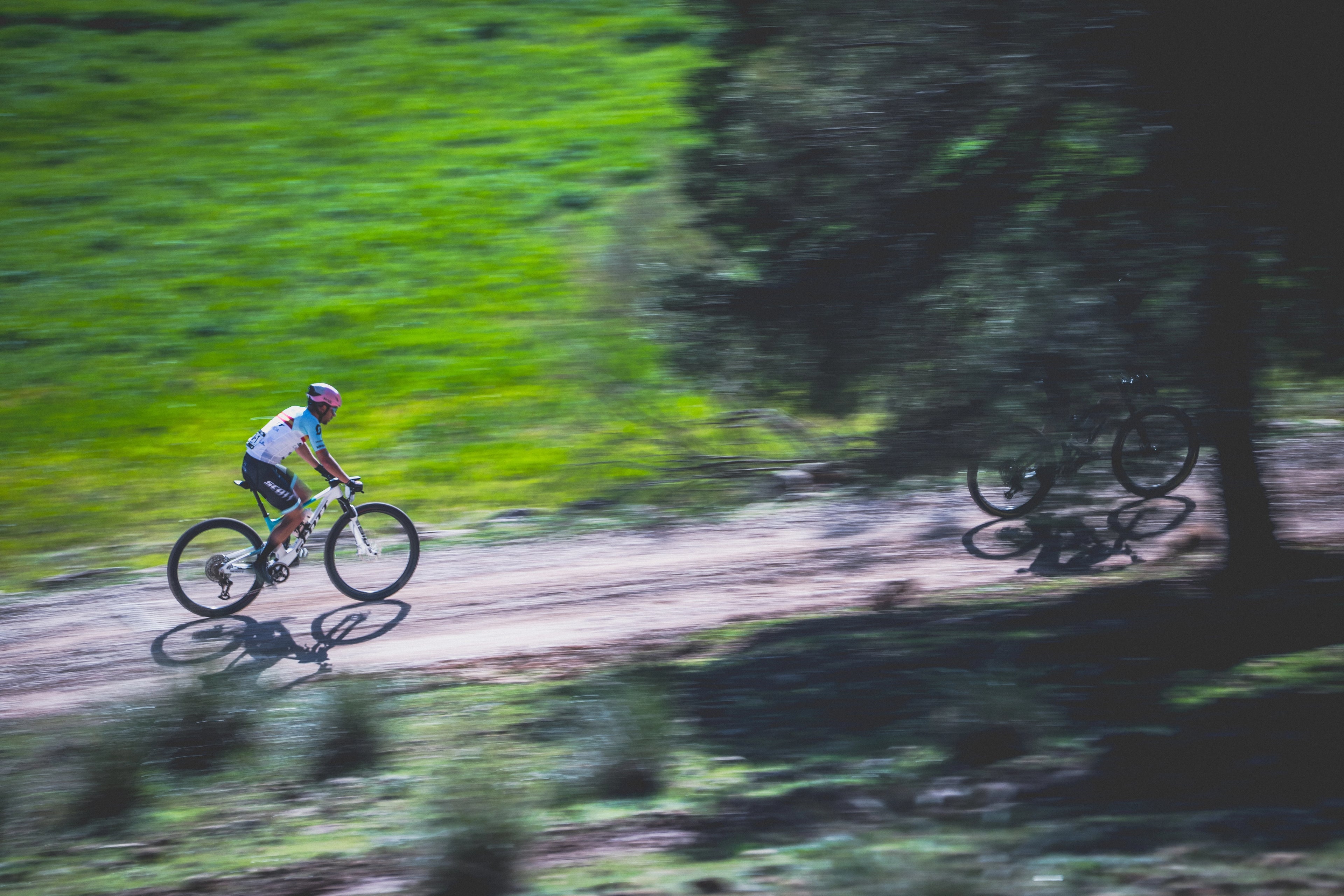 carretera de arbusto y tierra corrdor de bici gravel con casco rosa en ruta 