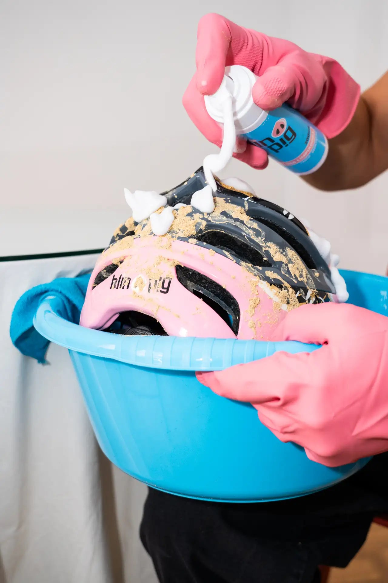 casco rosa y negro sucio guantes rosa envase blanco con etiqueta azul