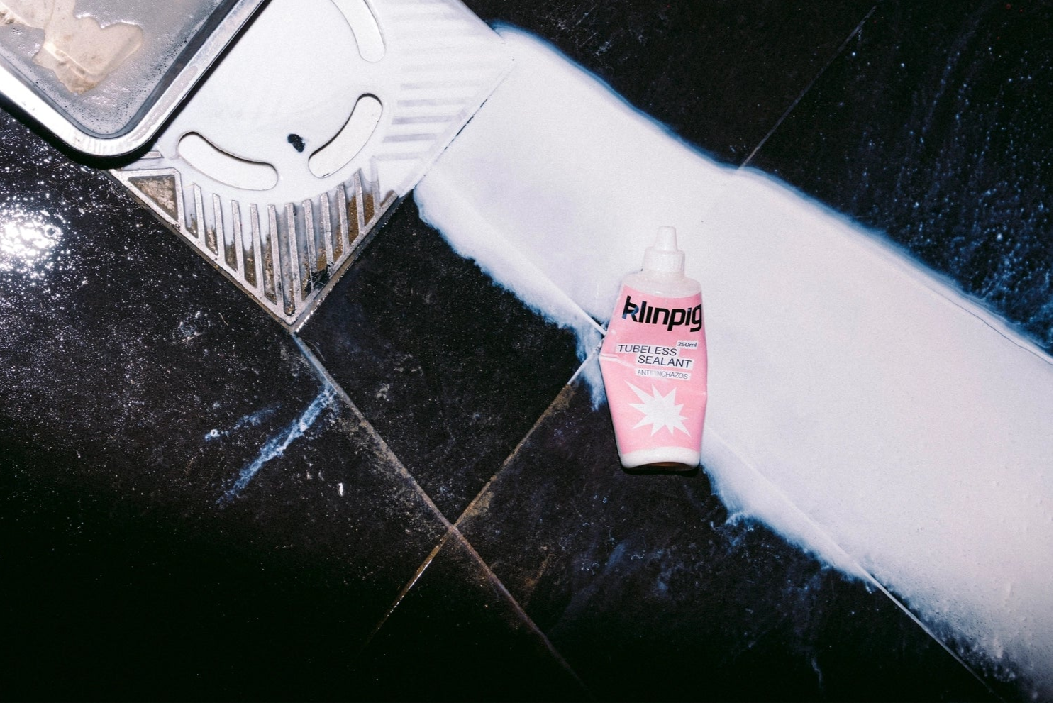 producto tubeless de color rosa derramado en el suelo 